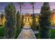 Inviting front entrance showcasing a walkway lined with mature trees and palms leading to the arched doorway at 3937 E Norcroft Cir, Mesa, AZ 85215