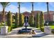 Elegant home exterior with a decorative fountain, palm trees, and manicured landscaping at 3937 E Norcroft Cir, Mesa, AZ 85215