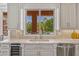 Kitchen sink with outdoor view; stone counters, stainless steel appliances, and custom white cabinetry at 3937 E Norcroft Cir, Mesa, AZ 85215