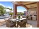 Inviting covered outdoor space with dining area, lounge seating, and views of lush landscaping and pool at 3937 E Norcroft Cir, Mesa, AZ 85215