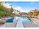 Resort-style pool area featuring a diving board, rock waterfall, lush landscaping, and comfortable lounge seating at 3937 E Norcroft Cir, Mesa, AZ 85215