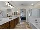 Bright bathroom with a large vanity, double sinks, and an arched doorway leading to the bedroom at 40830 W Bedford Dr, Maricopa, AZ 85138