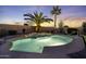 Backyard swimming pool with palm trees and lighting, creating an inviting outdoor oasis at dusk at 40830 W Bedford Dr, Maricopa, AZ 85138