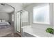 Bright bathroom featuring a tub, separate shower with glass doors, and neutral wall paint at 4171 E Dublin Ct, Gilbert, AZ 85295