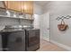 Functional laundry room with wood cabinets and shelving offers an efficient laundry setup at 4171 E Dublin Ct, Gilbert, AZ 85295