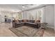 Inviting living room with a gray sectional sofa, rug, and open access to a modern white kitchen at 4171 E Dublin Ct, Gilbert, AZ 85295