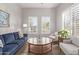 Elegant living room with a blue sofa, stylish furnishings, and ample natural light from shuttered windows at 4171 E Dublin Ct, Gilbert, AZ 85295