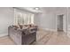 Bright living room featuring a gray sectional sofa, wooden floors, and large window with shutters at 4171 E Dublin Ct, Gilbert, AZ 85295