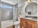 Well-lit bathroom featuring a wooden vanity, granite countertop, and a shower with gray tiling at 4929 W Christy Dr, Glendale, AZ 85304