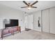 Modern bedroom with a ceiling fan, closet, and a wooden TV stand for comfortable relaxation at 4929 W Christy Dr, Glendale, AZ 85304