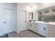 Bright bathroom featuring double sinks, modern fixtures, and a sleek, glass-enclosed shower at 5038 W Cheryl Dr, Glendale, AZ 85302