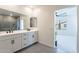 This bathroom features a double vanity with white cabinets and leads to a bedroom with a ceiling fan at 5038 W Cheryl Dr, Glendale, AZ 85302