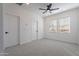 Cozy bedroom featuring neutral carpet, white walls, and a ceiling fan for added comfort at 5038 W Cheryl Dr, Glendale, AZ 85302