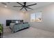 Light-filled bedroom with a large bed, neutral carpet, and modern ceiling fan at 5038 W Cheryl Dr, Glendale, AZ 85302