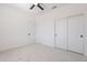 Bedroom with fresh neutral paint and carpet, ceiling fan, closet, and two-panel door at 5038 W Cheryl Dr, Glendale, AZ 85302