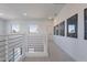 Upstairs hallway boasts modern railings, artwork, neutral carpet, and natural light at 5038 W Cheryl Dr, Glendale, AZ 85302