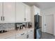 Contemporary kitchen featuring white cabinets, sleek appliances, and stylish herringbone backsplash at 5038 W Cheryl Dr, Glendale, AZ 85302