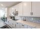 Well-lit kitchen showcasing white cabinets, quartz countertops, and modern stainless steel appliances at 5038 W Cheryl Dr, Glendale, AZ 85302