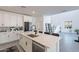 Modern kitchen with white cabinets, quartz countertops, stainless steel appliances, and an island with seating at 5038 W Cheryl Dr, Glendale, AZ 85302