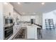 Modern kitchen featuring white cabinets, stainless steel appliances, and an island flowing into the living area at 5038 W Cheryl Dr, Glendale, AZ 85302