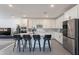 Modern kitchen featuring a central island with bar stools, stainless steel appliances, and ample storage at 5038 W Cheryl Dr, Glendale, AZ 85302