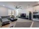 Bright living room with modern ceiling fan, gray L couch, and decorative accents at 5038 W Cheryl Dr, Glendale, AZ 85302