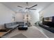 Bright living room with modern ceiling fan, gray L couch, and decorative accents at 5038 W Cheryl Dr, Glendale, AZ 85302