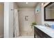 Modern bathroom featuring a double vanity, decorative mirror, modern lighting, and tiled shower at 5205 N 8Th Pl, Phoenix, AZ 85014