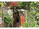 Inviting entrance with a rustic gate, climbing vines, and vibrant bougainvillea overhead creating a lush garden entryway at 5205 N 8Th Pl, Phoenix, AZ 85014