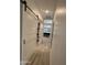 Hallway featuring a barn door closet and view into bathroom with black vanity and lighting at 5205 N 8Th Pl, Phoenix, AZ 85014