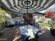 Picturesque patio with outdoor dining under a striped umbrella, surrounded by lush landscaping and plants at 5205 N 8Th Pl, Phoenix, AZ 85014