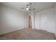 Neutral carpeted bedroom with ceiling fan and two entry doors allowing plenty of natural light at 523 S 201St Ave, Buckeye, AZ 85326