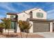 Inviting home exterior featuring a two-car garage, desert landscaping, and a light stucco facade at 523 S 201St Ave, Buckeye, AZ 85326