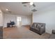 Comfortable living room offers neutral walls, carpet flooring, modern furnishings, and a ceiling fan at 523 S 201St Ave, Buckeye, AZ 85326