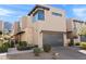 Modern home exterior with a gray garage door, stone accents, desert landscaping, and mountain views at 5541 E Stella Ln, Paradise Valley, AZ 85253