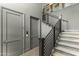 Modern staircase with neutral carpet, a metal railing, and gray doors at 5541 E Stella Ln, Paradise Valley, AZ 85253