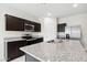 A modern kitchen featuring stainless steel appliances, granite countertops, and dark cabinetry at 5584 E Rock Bush Ln, San Tan Valley, AZ 85140