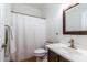 Neutral bathroom featuring white shower curtain, toilet, vanity, sink, and brown framed mirror at 6105 W Kimberly Way, Glendale, AZ 85308