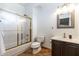 Bathroom featuring shower, toilet, vanity, sink, brown cabinet, and mirror at 6105 W Kimberly Way, Glendale, AZ 85308