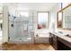 Bright bathroom featuring a glass shower, soaking tub, and travertine tile floor at 6105 W Kimberly Way, Glendale, AZ 85308