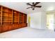 Bedroom featuring a large built-in bookcase, ceiling fan, and neutral carpet at 6105 W Kimberly Way, Glendale, AZ 85308