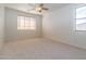 Bright bedroom with neutral carpet, ceiling fan, window with blinds, and electrical outlets at 6105 W Kimberly Way, Glendale, AZ 85308