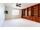 Spacious bedroom featuring a large built-in bookcase, ceiling fan, and light-filled window at 6105 W Kimberly Way, Glendale, AZ 85308