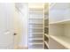 Bright, white walk-in closet with shelving and hanging racks for optimal organization at 6105 W Kimberly Way, Glendale, AZ 85308