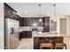 Modern kitchen with stainless steel appliances, dark cabinets, and granite countertops at 6713 E Elmwood St, Mesa, AZ 85205