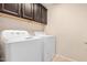 Convenient laundry room with upper cabinets, a modern washer, and a dryer at 6713 E Elmwood St, Mesa, AZ 85205