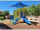 Community playground with blue slide, climbing feature, awning and green climbing rungs for active fun at 6713 E Elmwood St, Mesa, AZ 85205