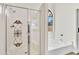 Bathroom features tiled shower with decorative window and soaking tub at 7038 N 28Th Ave, Phoenix, AZ 85051