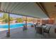 Spacious covered patio featuring a view of the sparkling pool and outdoor dining set at 7102 E Larkspur Dr, Scottsdale, AZ 85254