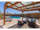 Relaxing backyard with a covered pergola, pool, and cozy seating area at 7102 E Larkspur Dr, Scottsdale, AZ 85254